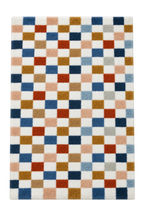 A rectangular area rug with a geometric checkered pattern in white, navy, blue, rust red, tan, beige, and light gray, shown from a top-down view on a white background.